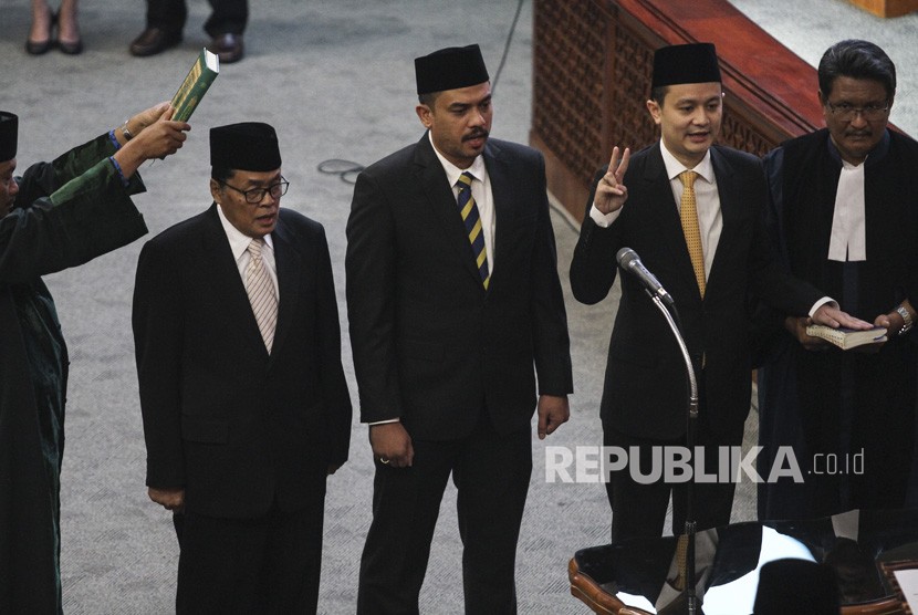 Anggota DPR HM Gandung Pardiman (kedua kiri), Maman Abdurahman (tengah) dan Jerry Sambuaga (kedua kanan) mengucap sumpah jabatan saat dilantik pada Rapat Paripurna DPR di Kompleks Parlemen Senayan, Jakarta, Kamis (26/7).