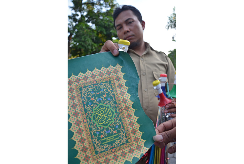 Anggota Intel Korem 162/Wira Bhakti menunjukkan kertas bahan terompet sampul Al Quran bertuliskan Kementrian Agama RI Tahun 2013 saat diamankan di Kantor Intel Korem 162/Wira Bhakti Mataram, NTB, Selasa (29/12). 