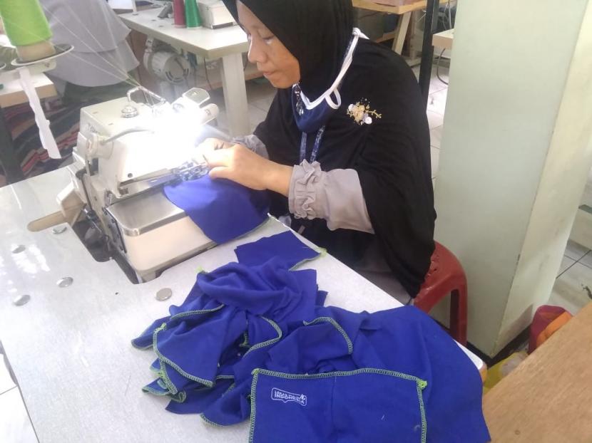 Anggota Kelompok Karya Cacat Berkreasi (KCB) Anggrek sedang melakukan proses penjahitan pesanan masker di pusat workshop mereka di Kelurahan Bahagia, Kecamatan Babelan, Kabupaten Bekasi. 