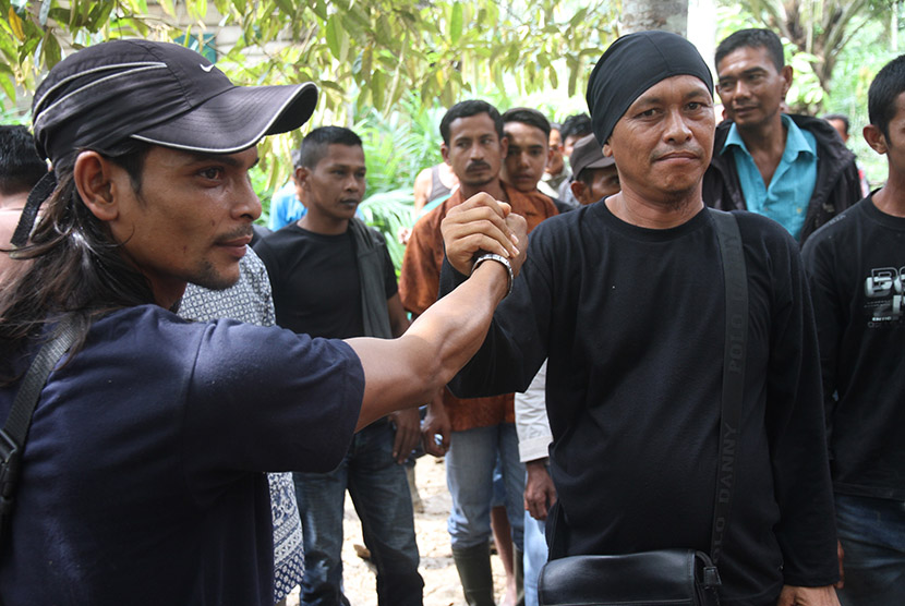 Anggota kelompok sipil bersenjata dibawah pimpinan Nurdin alias Din Minimi berfoto bersama setelah penyerahan senjata di Desa Ladang Baro, Kecamatan Julok, Aceh Timur, Aceh, Selasa (29/12). (Antara/Syifa Yulinnas)