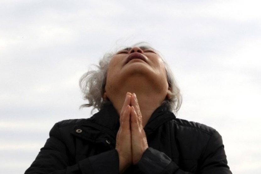 Anggota keluarga korban tragedi feri Sewol berdoa sambil menunggu kabar di Jindo, Selasa (22/4)