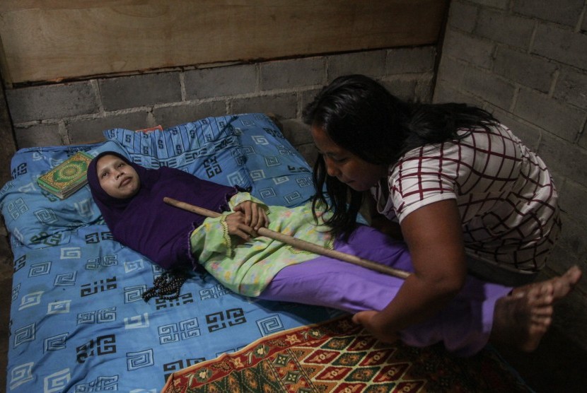 Anggota keluarga membantu menaikkan Sulami (35) penderita penyakit langka punggung kayu atau 'bamboo spin' ke tempat tidur di rumahnya Desa Mojokerto, Kedawung, Sragen, Jawa Tengah, Senin (23/1). 