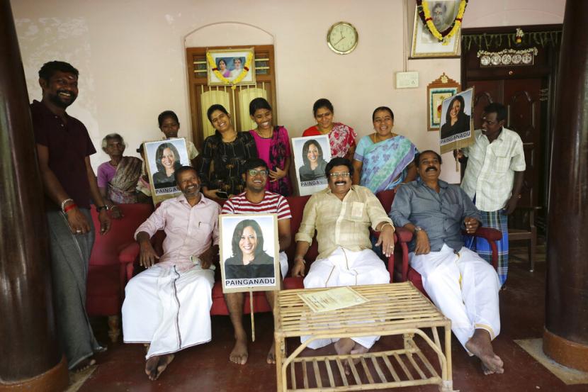 Anggota keluarga Vandayar berpose di rumah moyang mereka dengan mengusung foto Kamala Harris di desa Thulasendrapuram, selatan dari Chennai, Tamil Nadu, India, Sabtu (7/11). Desa Thulasendrapuram adalah kampung halaman kakek Kamala Harris yang bermigrasi dari sana beberapa dekade lalu. 