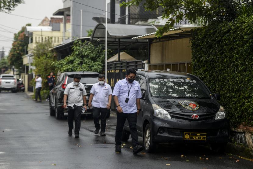 Anggota kepolisian berjalan di samping rumah dinas Kadiv Propam Polri Irjen Pol Ferdy Sambo saat berlangsungnya olah TKP di Kompleks Polri Duren Tiga, Jakarta. Lemkapi meminta Polisi segera mengumumkan hasil investigasi penembakan di rumah Sambo