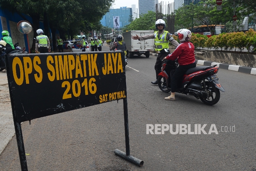  Anggota Kepolisian dari Polda Metro Jaya memeriksa kelengkapan surat berkendara pengemudi saat menggelar Operasi Simpatik Jaya di Jalan Rasuna Said, Jakarta Selatan, Ahad (20/3). (Republika/Raisan Al Farisi)