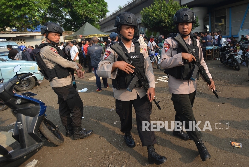 Anggota Kepolisian dengan senjata lengkap berjaga di sekitar Tempat Kejadian Perkara (TKP) dugaan bom bunuh diri di Terminal Kampung Melayu, Jakarta Timur, Rabu (25/5). 