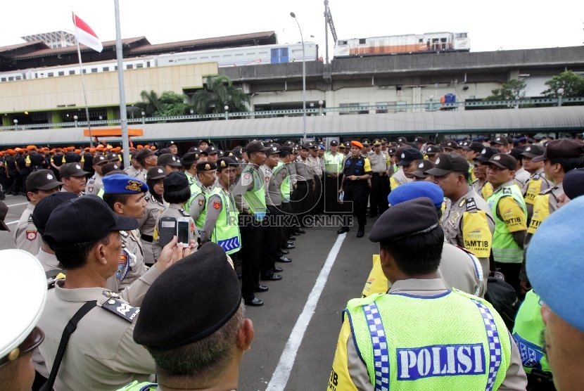  Anggota kepolisian melakukan briefing usai apel siaga pengamanan Natal dan Tahun Baru 2015 di lapangan parkir Stasiun Gambir, Jakarta, Ahad (19/12). (Republika/Rakhmawaty La’lang)