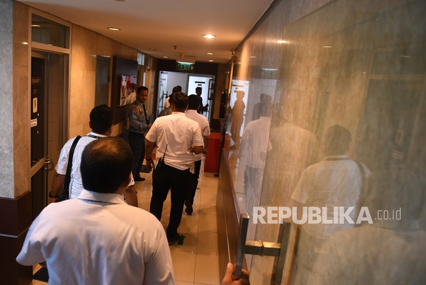 Anggota kepolisian memasuki ruangan yang terkena peluru nyasar di Kompleks Parlemen, Senayan, Jakarta, Senin (15/10).