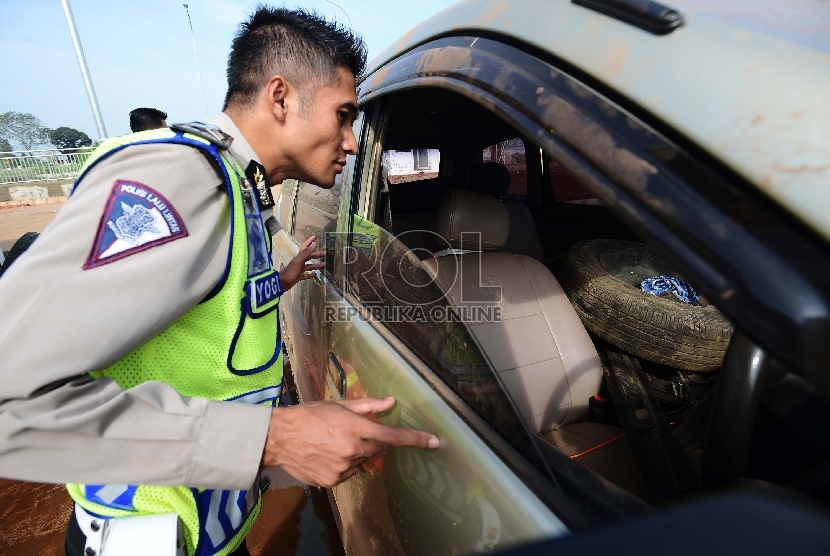  Anggota kepolisian memeriksa mobil yang telah mengalami kecelakaan di ruas Jalan Tol Cipali, Jawa Barat, Jumat (10/7).  (Republika/Raisan Al Farisi)