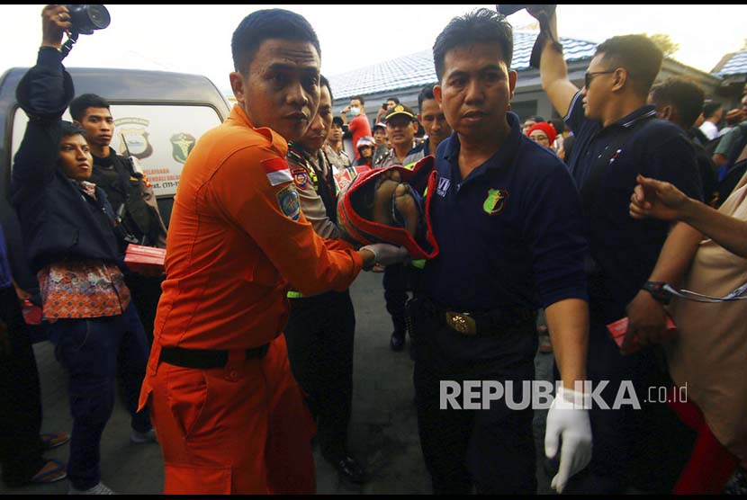 Anggota kepolisian mengangkat jenazah salah satu korban kapal motor Arista yang tenggelam di Rumah Sakit Jala Ammari, Makassar, Sulawesi Selatan, Rabu (13/6).