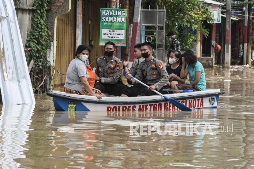 Anggota kepolisian mengevakuasi warga saat banjir di Pondok Gede Permai, Bekasi, Jawa Barat, Kamis (17/2/2022). Banjir akibat luapan kali Bekasi merendam rumah warga pada pukul 01.00 WIB dengan ketinggian 30 cm sampai dengan 90 cm. 