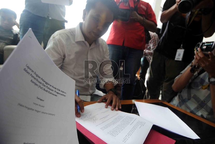 Anggota Koalisi Masyarakat Sipil, Erwin Natosmal menandatangai laporan dugaan pelanggaran kode etik hakim saat mengadukan Hakim Sarpin Rizaldi ke Komisi Yudisial (KY), Selasa (17/2). 