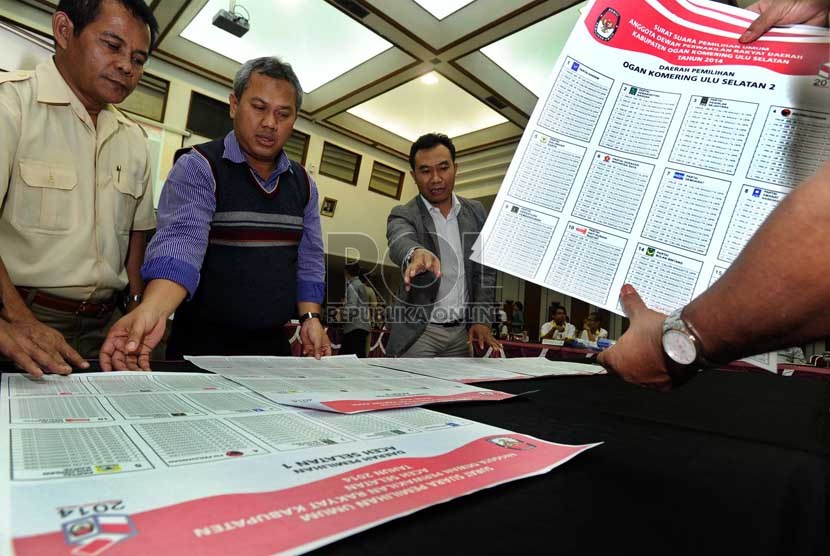  Anggota Komisi Pemilihan Umum (KPU) Arief Budiman (kedua kiri), anggota KPU Sigit Pamungkas (ketiga kiri) mengecek dummy surat suara saat penandatanganan draft oleh partai politik di kantor KPU, Jakarta, Selasa (3/12).     (Republika/ Tahta Aidilla)  