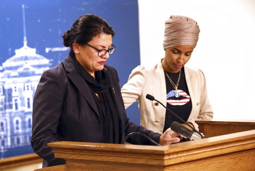 Anggota Kongres AS Ilhan Omar (kanan) menenangkan rekannya Rashida Tlaib di State Capitol, St. Paul, Minnesota, Senin (19/8). Israel melarang mereka mengunjungi Israel dan Tepi Barat.