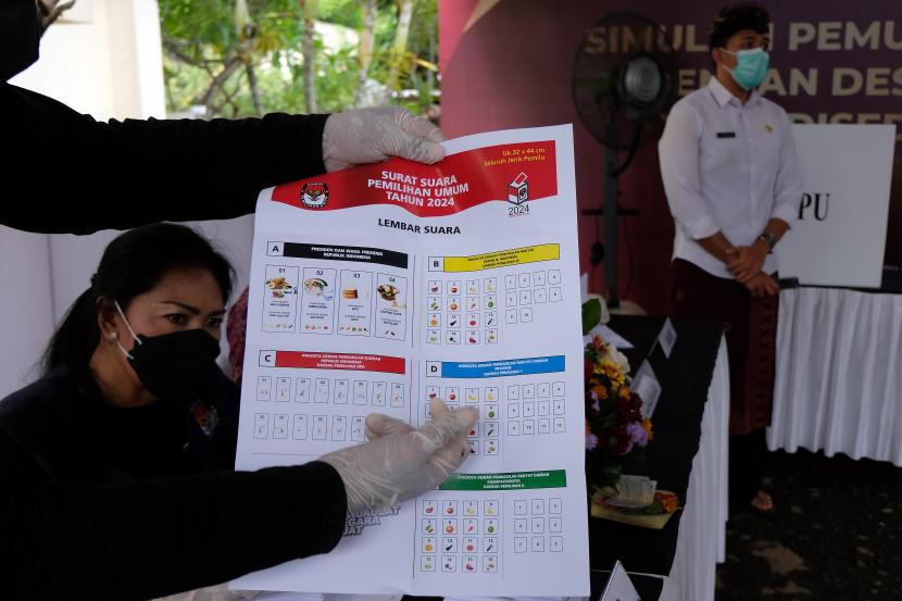 Anggota KPPS menunjukkan surat suara kepada pemilih saat simulasi pemungutan dan penghitungan suara dengan desain surat suara dan formulir yang disederhanakan dalam persiapan penyelenggaraan Pemilu serentak tahun 2024 di Kantor KPU Provinsi Bali, Denpasar, Bali, Kamis (2/12/2021).