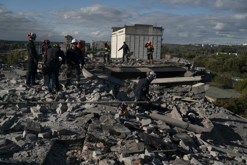 Anggota layanan penyelamatan bekerja untuk membersihkan puing-puing dan struktur tidak stabil yang bisa jatuh, di atap sebuah bangunan tempat tinggal yang rusak setelah serangan Rusia di Kharkiv, Ukraina, Rabu, 21 September 2022. 