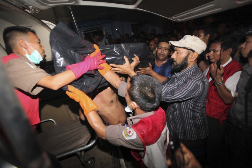  Anggota palang merah Myanmar dan warga Muslim mengangkat kantong jenazah korban kebakaran yang terjadi di sebuah masjid di Yangon, Myanmar, Selasa (2/4). (AP/Khin Maung Win)