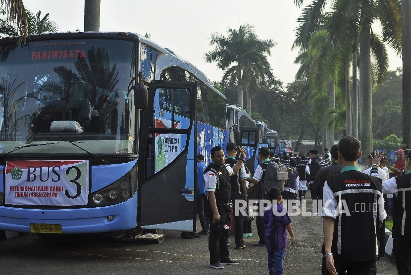 Anggota Panitia Penyelenggara Ibadah Haji (PPIH) berjalan menuju bus seusai upacara saat pemberangkatan PPIH 1438 Hijriyah di Asrama Haji Pondok Gede, Jakarta, Selasa (25/7).