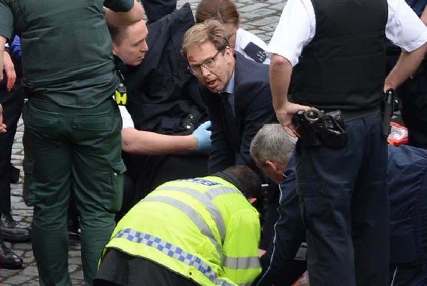 Anggota parlemen dari partai konservatif Tobias Ellwood saat mencoba menyelamatkan polisi korban penusukan di luar gedung parlemen Inggris di London, Rabu (22/3).