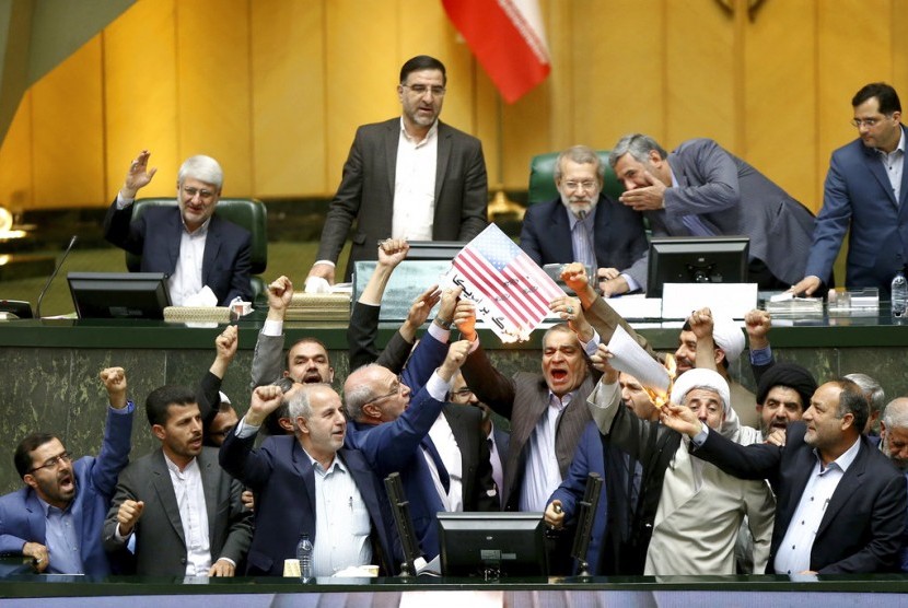 Anggota parlemen Iran membakar bendera AS.