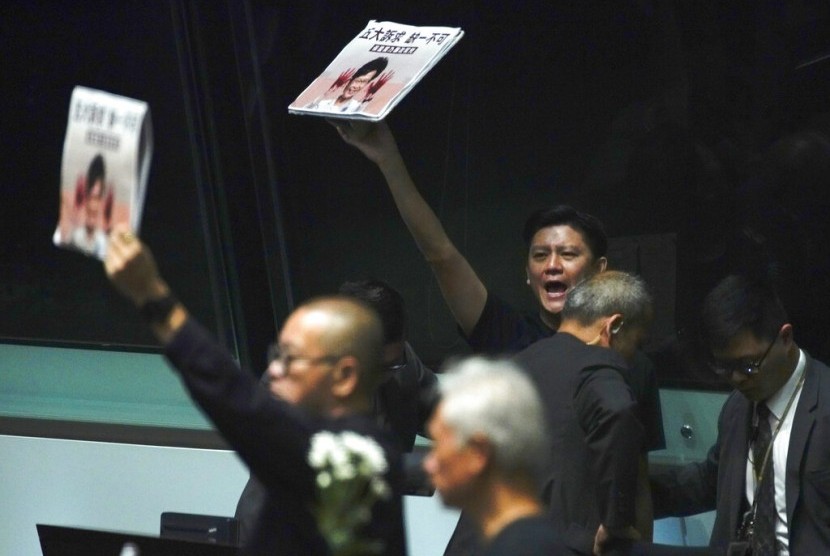 Anggota parlemen oposisi menunjukkan poster bergambar Ketua Eksekutif Hong Kong Carrie Lam saat berpidato di Majelis Legislatif, Hong Kong, Kamis (17/10).