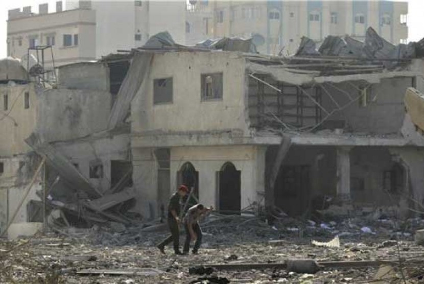  Anggota pasukan keamanan Hamas menelusuri puing-puing bangunan yang hancur terkena serangan udara Israel di Gaza, Palestina, pada Sabtu (23/6). 