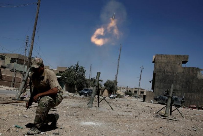 Anggota pasukan reaksi cepat Irak menembakkan mortar kepada posisi militan ISIS di barat Mosul, Irak.