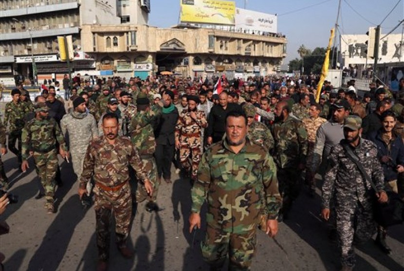 Anggota pasukan Syiah berdemonstrasi di Tahrir Square, Baghdad menuntut penarikan pasukan Turki dari Irak, Sabtu, 12 Desember 2015.