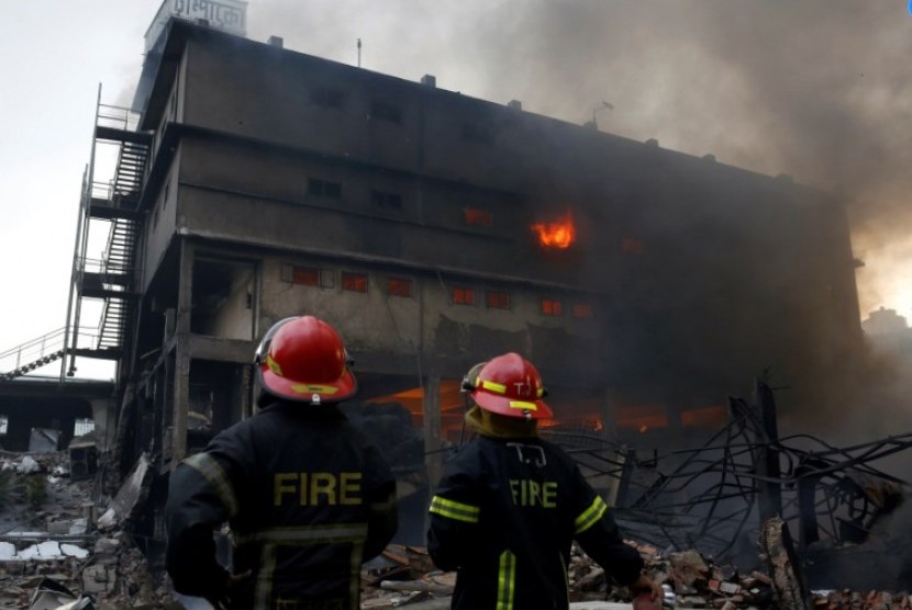 Anggota pemadam kebakaran tengah memadamkan api yang membakar pabrik di 