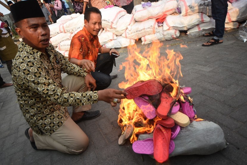 Anggota Pengurus Wilayah Nahdlatul Ulama (PWNU) Jawa Timur menunjukkan sandal berlafadz Allah yang siap dimusnahkan, di Kantor PWNU Jawa Timur, Surabaya, Selasa (13/10).  (Antara/M Risyal Hidayat)