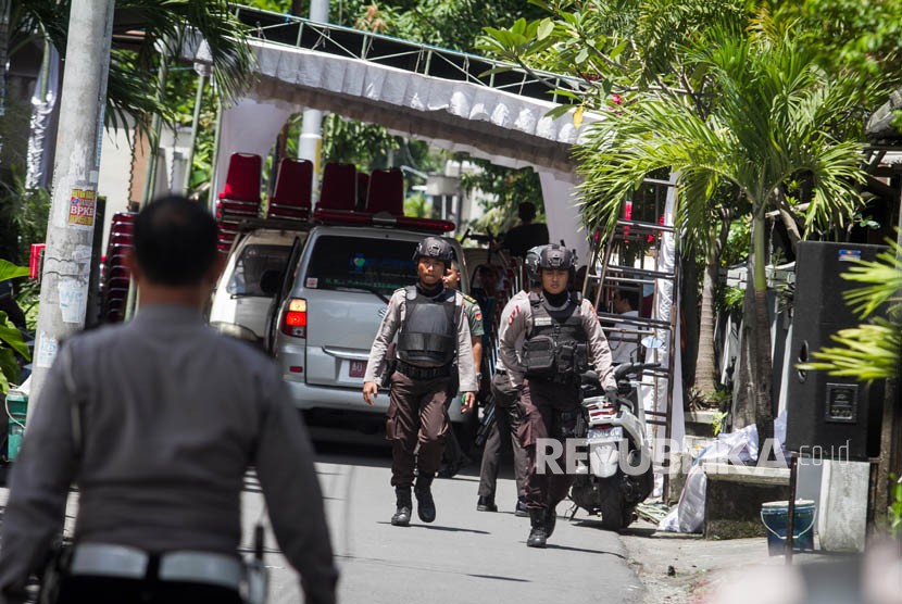 Anggota Polisi dan TNI menjaga mobil ambulans yang membawa jenazah Didiet Supriyadi, besan Presiden Joko Widodo, ketika tiba di rumah duka di kawasan Sumber, Solo, Jawa Tengah, Selasa (3/4). 