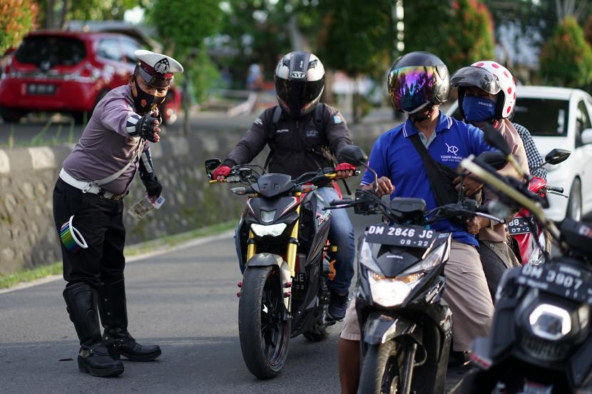 Anggota polisi lalu lintas memberhentika pengendara motor pada Operasi Zebra di Kota Gorontalo, Gorontalo, Senin (26/10/2020). Selain menertibkan pelanggaran lalu lintas, Operasi Zebra kali ini dilakukan dengan memberikan imbauan protokol kesehatan COVID-19. 