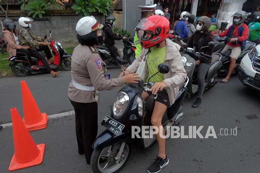 Anggota Polisi meminta Warga Negara Asing (WNA) yang tidak melengkapi persyaratan untuk putar balik saat penyekatan Pemberlakuan Pembatasan Kegiatan Masyarakat (PPKM) Darurat di Pos Teuku Umar Barat - Gunung Salak, Denpasar, Bali, Kamis (8/7/2021). Operasi penyekatan yang digelar di 7 titik pintu masuk Kota Denpasar tersebut untuk membatasi mobilitas orang dan mencegah penyebaran varian baru COVID-19 menyusul meningkatnya kasus positif COVID-19 di ibu kota Provinsi Bali itu. 