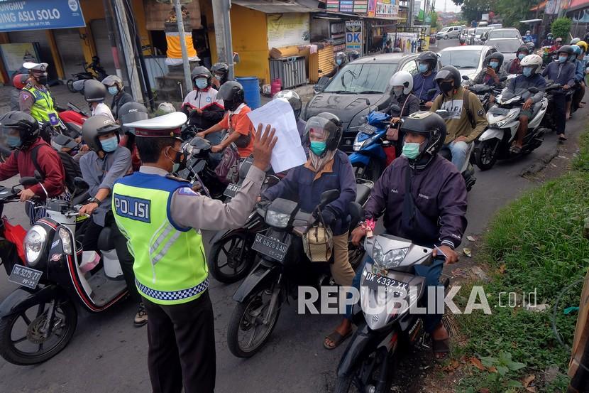 Anggota Polisi meminta warga untuk menunjukkan surat keterangan kerja saat penyekatan Pemberlakuan Pembatasan Kegiatan Masyarakat (PPKM) Darurat di Pos Teuku Umar Barat - Gunung Salak, Denpasar, Bali, Kamis (8/7/2021). Operasi penyekatan yang digelar di 7 titik pintu masuk Kota Denpasar tersebut untuk membatasi mobilitas orang dan mencegah penyebaran varian baru COVID-19 menyusul meningkatnya kasus positif COVID-19 di ibu kota Provinsi Bali itu. 
