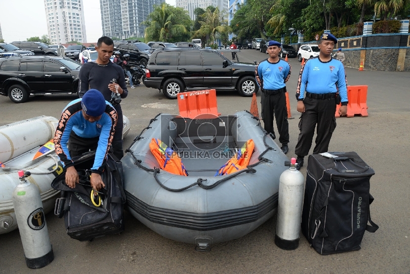 Anggota polisi mempersiapkan perahu karet saat apel kesiapan waspada bencana banjir di halaman Markas Polda Metro Jaya, Jakarta, Jumat (27/11).
