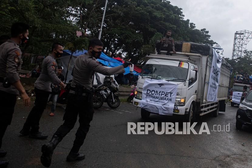 Anggota polisi mengamankan truk yang membawa bantuan logistik untuk korban bencana (ilustrasi).