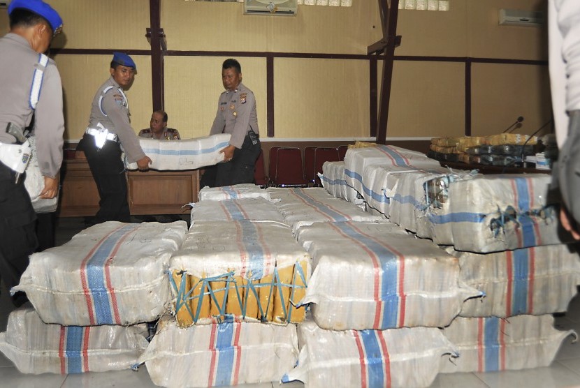 Anggota polisi menggotong karung berisi ganja bagian dari 1,7 ton ganja kering yang disita dari bandar narkoba di Serang, Banten, Rabu (2/12). 