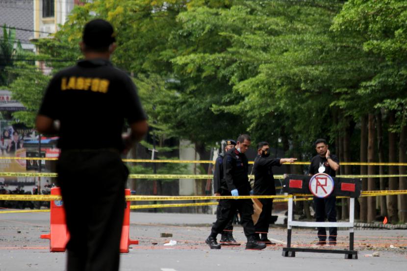 Anggota polisi mengumpulkan sisa serpihan ledakan bom bunuh diri di depan Gereja Katedral Makassar, Sulawesi Selatan, Senin (29/3/2021). Kepolisian masih melakukan olah TKP serta mengumpulkan serpihan sisa ledakan pada hari kedua pascaledakan bom bunuh diri yang terjadi pada Minggu (28/3/2021) di depan gereja tersebut.