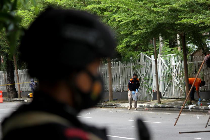 Anggota polisi mengumpulkan sisa serpihan ledakan bom bunuh diri di depan Gereja Katedral Makassar, Sulawesi Selatan, Senin (29/3/2021). Kepolisian masih melakukan olah TKP serta mengumpulkan serpihan sisa ledakan pada hari kedua pascaledakan bom bunuh diri yang terjadi pada Minggu (28/3/2021) di depan gereja tersebut.