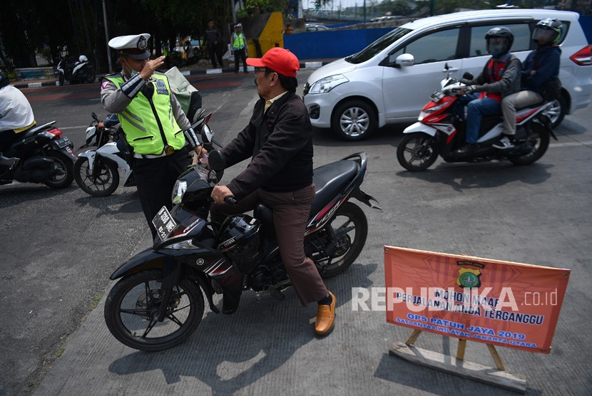 Anggota Polisi Satlantas Wilayah Jakarta Utara melakukan Operasi Patuh Jaya 2019 di Jalan Mangga Dua Raya, Jakarta Utara, Kamis (29/8/2019).