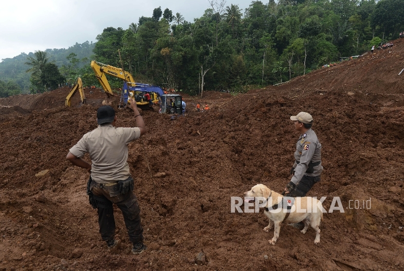 Anggota Polisi Satwa unit K-9 dari Mabes Polri membantu proses pencarian korban longsor yang terjadi di Desa Banaran, Kecamatan Pulung, Kabupaten Ponorogo, Jawa Timur, Kamis (6/4).