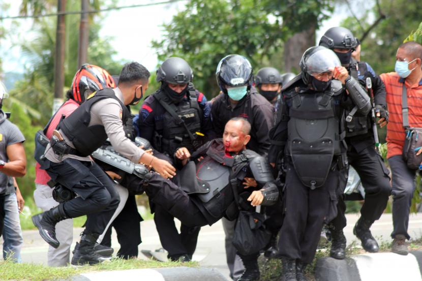 Anggota polisi yang terluka dievakuasi unjuk rasa di Kota Sorong, Papua Barat, Jumat (27/11/2020). Demonstrasi yang belum diketahui maksud dan tujuannnya tersebut dibubarkan kepolisian karena menyebabkan keramaian di tengah pandemi COVID-19 dan berlangsung ricuh sehingga mengakibatkan empat orang anggota polisi dan satu orang jurnalis terluka. 