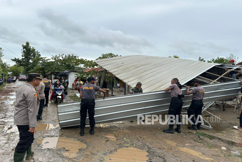 Anggota Polres Indramayu dan jajaran Polsek Pasekan bersama TNI dan BPBD  membantu evakuasi  pohon tumbang dan rumah warga yang roboh akibat angin puting beliung di Desa Pabean Ilir, Kecamatan Pasekan, Kabupaten Indramayu, Rabu (8/1/2025). 