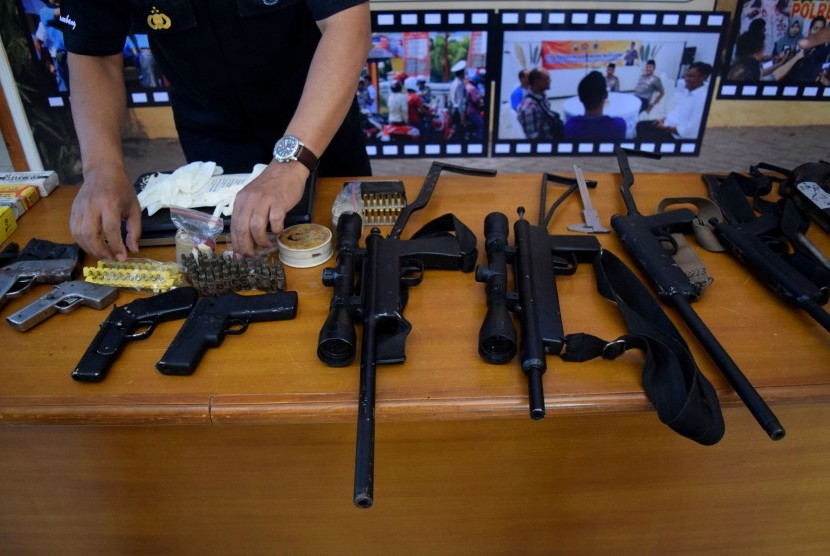 Anggota Polres Jombang menunjukkan barang bukti senjata api (senpi) rakitan dan ratusan peluru tajam saat rilis di Mapolres Jombang, Jawa Timur, Selasa (9/8). 