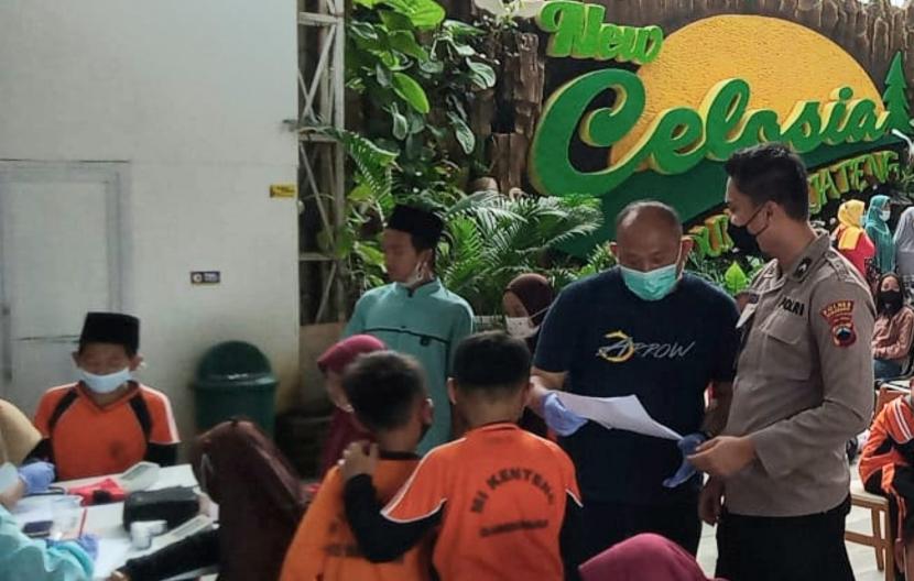 Anggota Polres Semarang melaksanakan vaksinasi jemput bola dengan saran anak usia 6 -11 tahun, di tempat wisata Taman Bunga Celosia, Kecamatan Bandungan, Kabupaten Semarang, Ahad (9/1). Selain tempat wisata, Polres Semarang juga melaksanakan vaksinasi jemput bola di pusat keramaian warga guna mendukung percepatan vaksinasi anak.