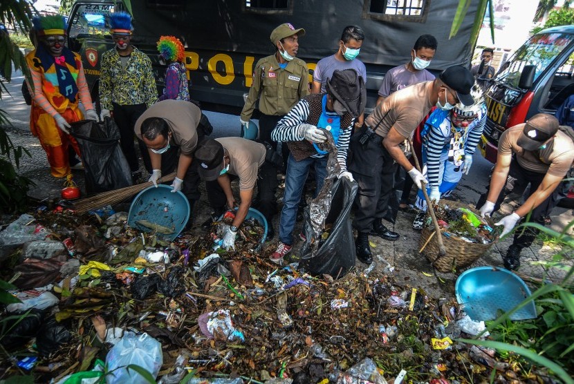 Sampah Nasional: Anggota Polres Tasikmalaya Kota dibantu Komunitas Badut Galeri Tasik (BGT), Pelajar dan Mahasiswa serta Penggiat Lingkungan membersihkan tumpukan sampah yang dibuang sembarangan pada aksi Peringati Sampah Nasional yang dibuang di Pinggir Jalan Kota Tasikmalaya, Jawa Barat, Kamis (21/2/2019). 