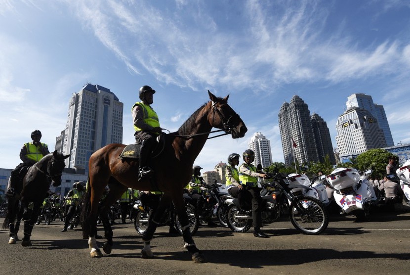 Anggota Polri berkuda dan bermotor meninggalkan lapangan seusai mengikuti apel Operasi Lilin 2015 di Polda Metro Jaya, Jakarta, Rabu (23/12).