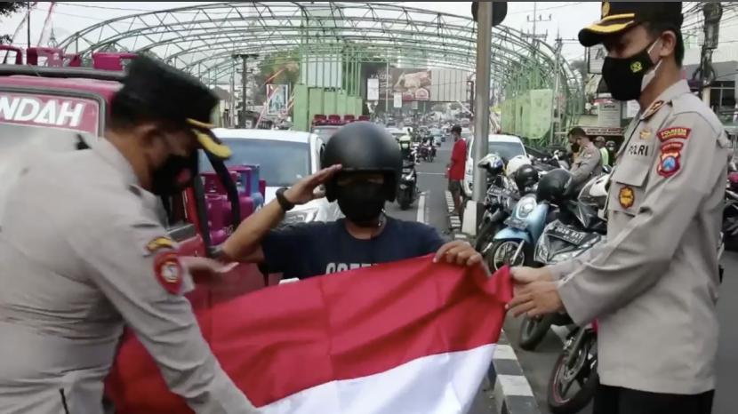 Anggota Polri dari jajaran Mapolresta Malang Kota membagikan 1.000 bendera Merah Putih kepada warga melalui para Bhayangkara Pembina Keamanan dan Ketertiban Masyarakat (Bhabinkamtibmas), Senin (16/8).