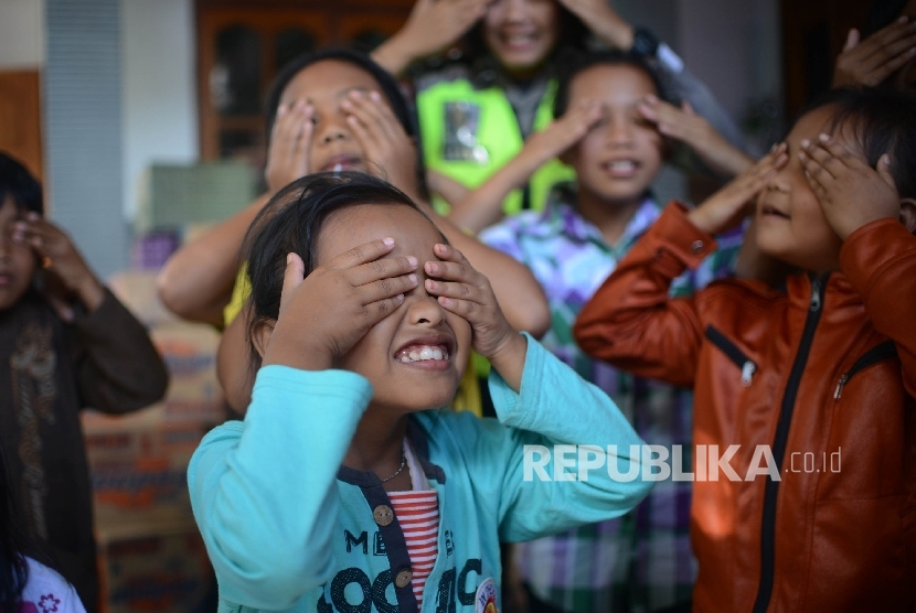 Anggota Polwan bermain dalam rangka trauma healing bersama anak-anak yang selamat dari longsor yang menimbun Desa Banaran, di Kecamatan Pulung, Ponorogo, Jawa Timur, Selasa (4/4). 