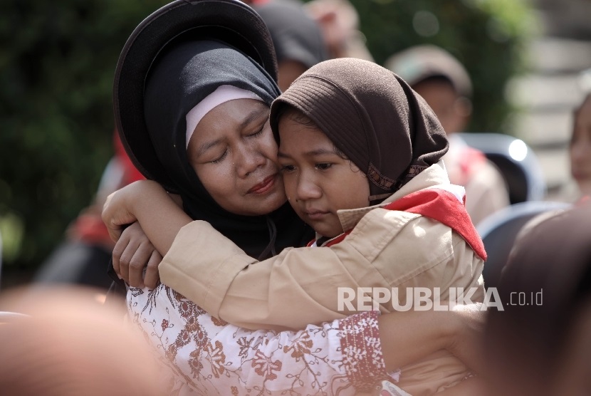 Anggota Pramuka berpelukan dengan ibunya usai membasuh kaki ibunya dalam acara kwartir nasional gerakan pramuka 'Membasuh kaki Ibu' di Taman Rekreasi Wiladatika, Jakarta Timur, Rabu (21/12). 